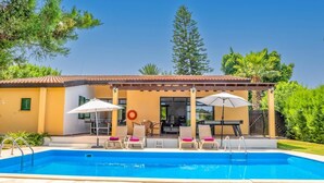 Uma área na piscina com um terraço coberto, assentos externos e uma piscina.