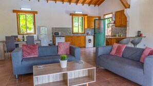 Uma sala de estar moderna com dois sofás cinzas, uma mesa de centro de madeira e uma planta em vaso.