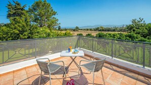 Eine Terrasse mit Tisch, zwei Stühlen und einem Paar Hausschuhen.
