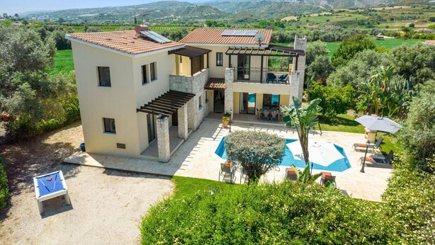 Ein zweistöckiges Haus mit Swimmingpool, Außenbereich und Blick auf die umliegende Landschaft.