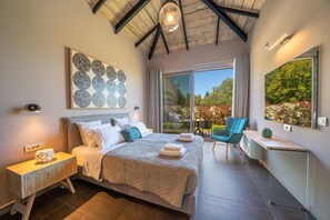 A bedroom with a bed, bedside table, and a view of the outdoors.