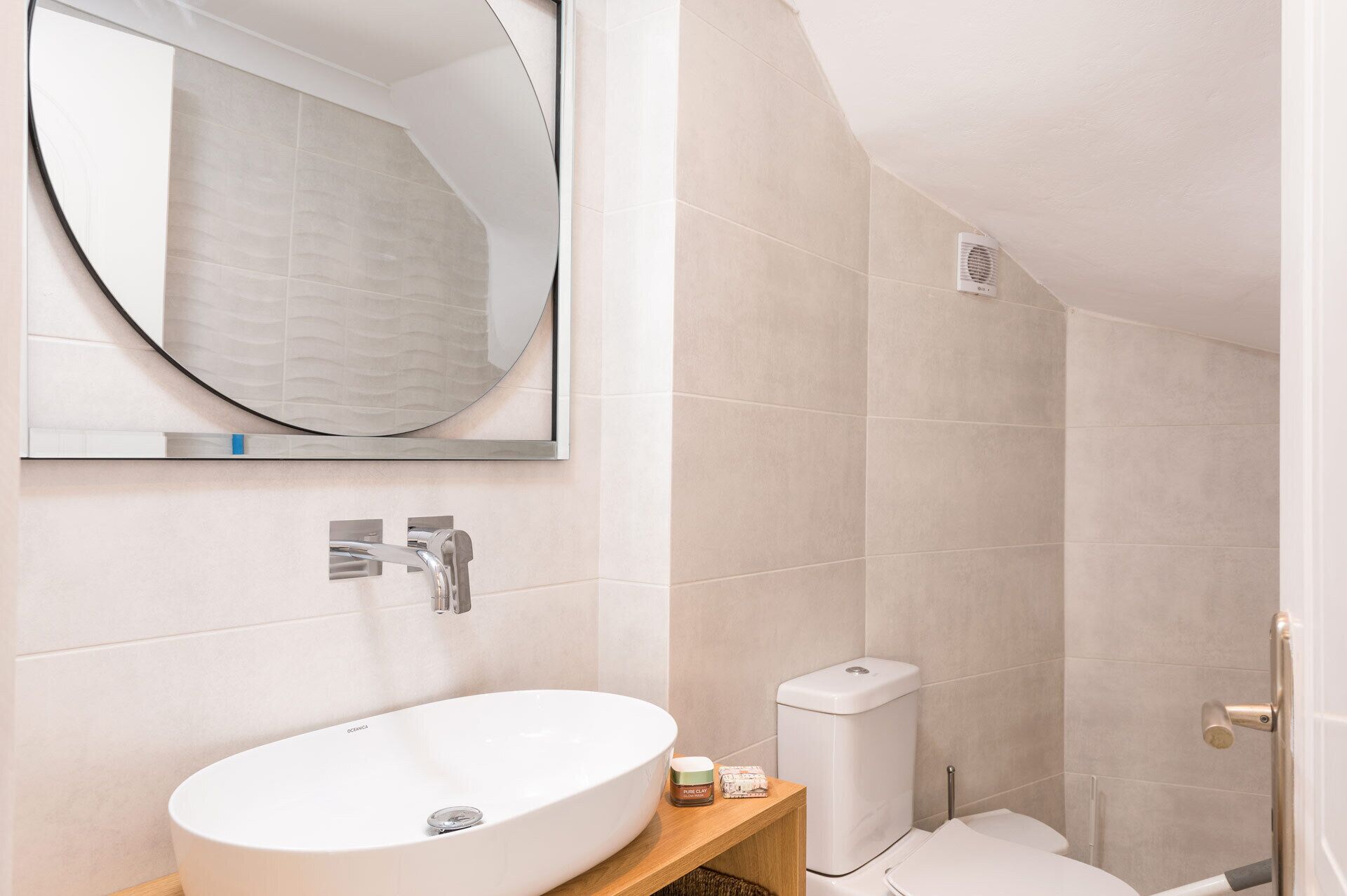 Une salle de bain avec un lavabo blanc, des toilettes et un espace douche.