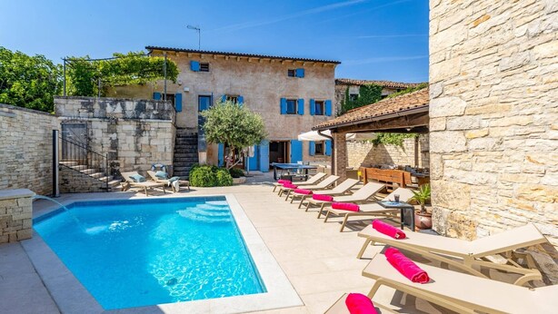 A pool area with lounge chairs and a stone building with blue shutters. - Villa Fumica by Villa Plus (Radetići)