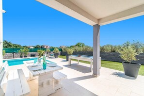 A covered outdoor area with a pool, lounge chairs, and a pool table. - Villa Florentina by Villa Plus (Stokovci)
