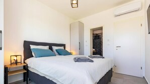A bedroom with a bed, bedside table, and a nightstand. - Villa Lavandula by Villa Plus (Stokovci)