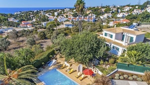 A residential area with a swimming pool, a red slide, and a view of the sea. - Villa Maisie by Villa Plus (Praia do Carvoeiro)