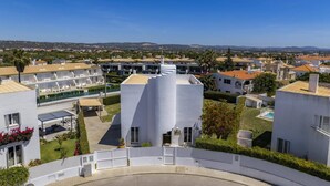 Una zona residencial moderna con edificios blancos, una piscina y vistas despejadas del paisaje circundante.