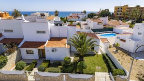 Zona residencial con edificios blancos, una piscina y vistas al mar.