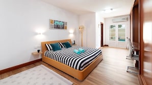Une chambre avec un lit, une table de chevet et une vue sur l’espace piscine.