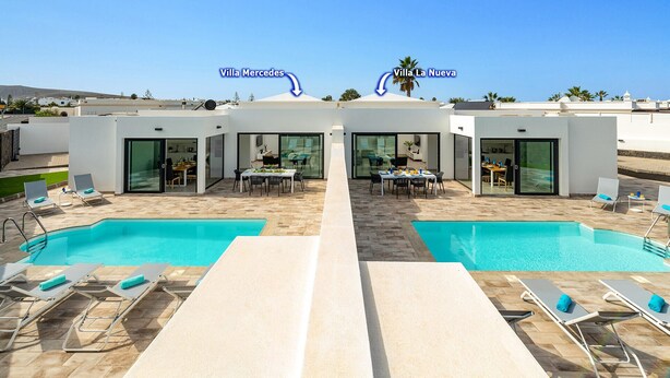 A modern villa with two swimming pools, outdoor dining areas, and lounge chairs. - Villa La Nueva by Villa Plus (Playa Blanca)