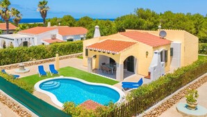 A pool area with a swimming pool, lounge chairs, and a covered patio. - Villa Luna by Villa Plus (Cap d'Artrutx)