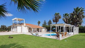 A house with a pool, outdoor seating, and a covered patio area. - Villa Clara Ispica by Villa Plus (Santa Maria del Focallo)