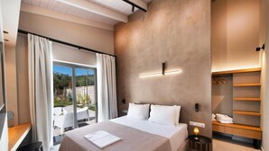 A modern bedroom with a large bed, a desk, and a view of the outdoors. - Villa Mandola Sweet by Villa Plus (Kariotes)