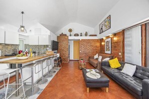 A modern living space with a kitchen, dining area, and seating area. - Villa Damasco by Villa Plus (Albufeira)