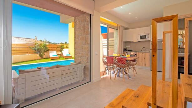 Un apartamento moderno con piscina, comedor y cocina.
