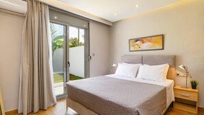 Une chambre à coucher moderne avec un grand lit, une table de chevet, une lampe et un tableau au mur.