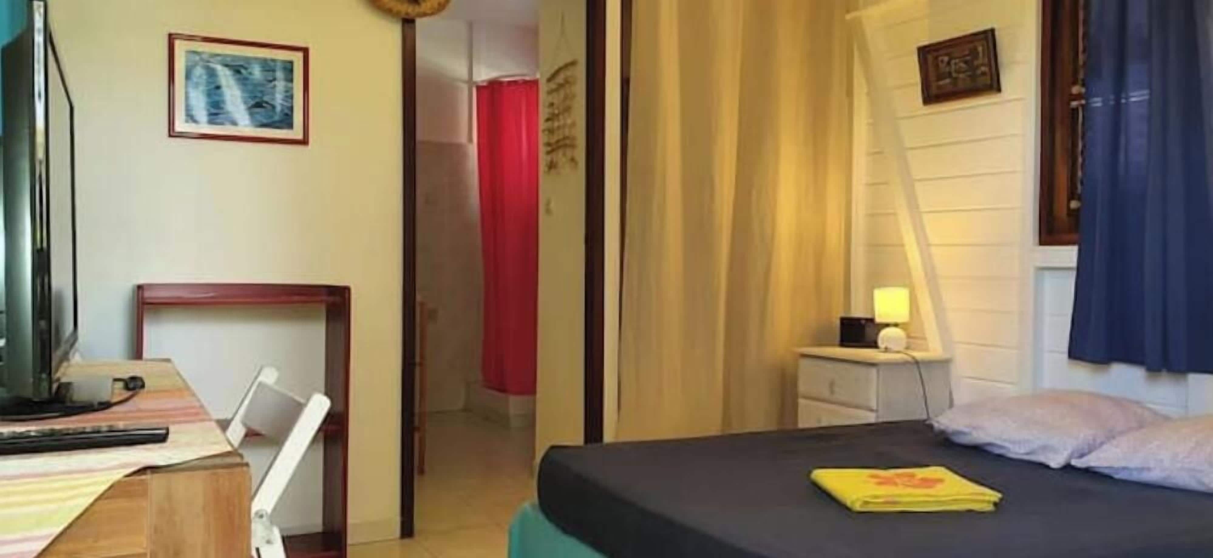 Une chambre d’hôtel équipée d’un lit, d’une table de chevet, d’une lampe et d’un téléviseur.