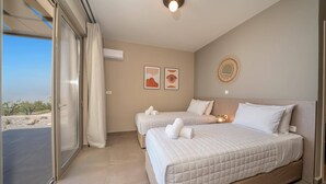Een hotelkamer met twee bedden, een groot raam met uitzicht op het landschap en een plafondlamp.
