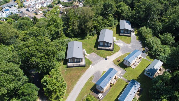 Vue aérienne d’un quartier résidentiel composé de maisons individuelles, entouré d’une végétation luxuriante.