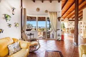 Relax in this open-plan living area with a balcony offering stunning sea views.