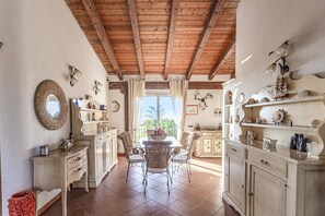 Enjoy meals at the central dining table surrounded by wicker chairs.
