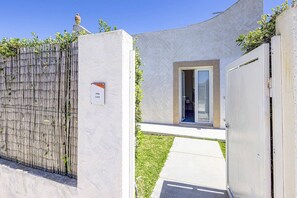 A villa with a gated entrance, a small door, and a sign indicating 'Villa Luce.'