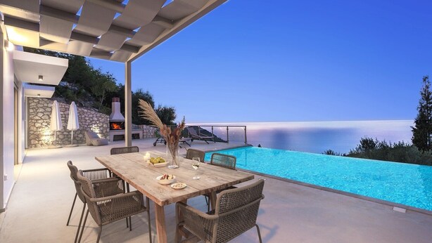 Ein Essbereich im Freien mit Pool und Blick aufs Meer.