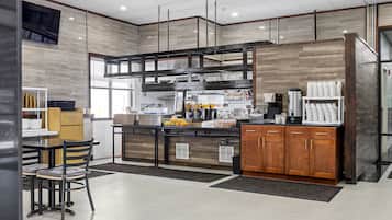 A modern kitchen with a central island, wooden cabinets, and a dining area with chairs.