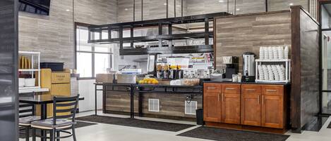 A modern kitchen with a central island, wooden cabinets, and a dining area with chairs.