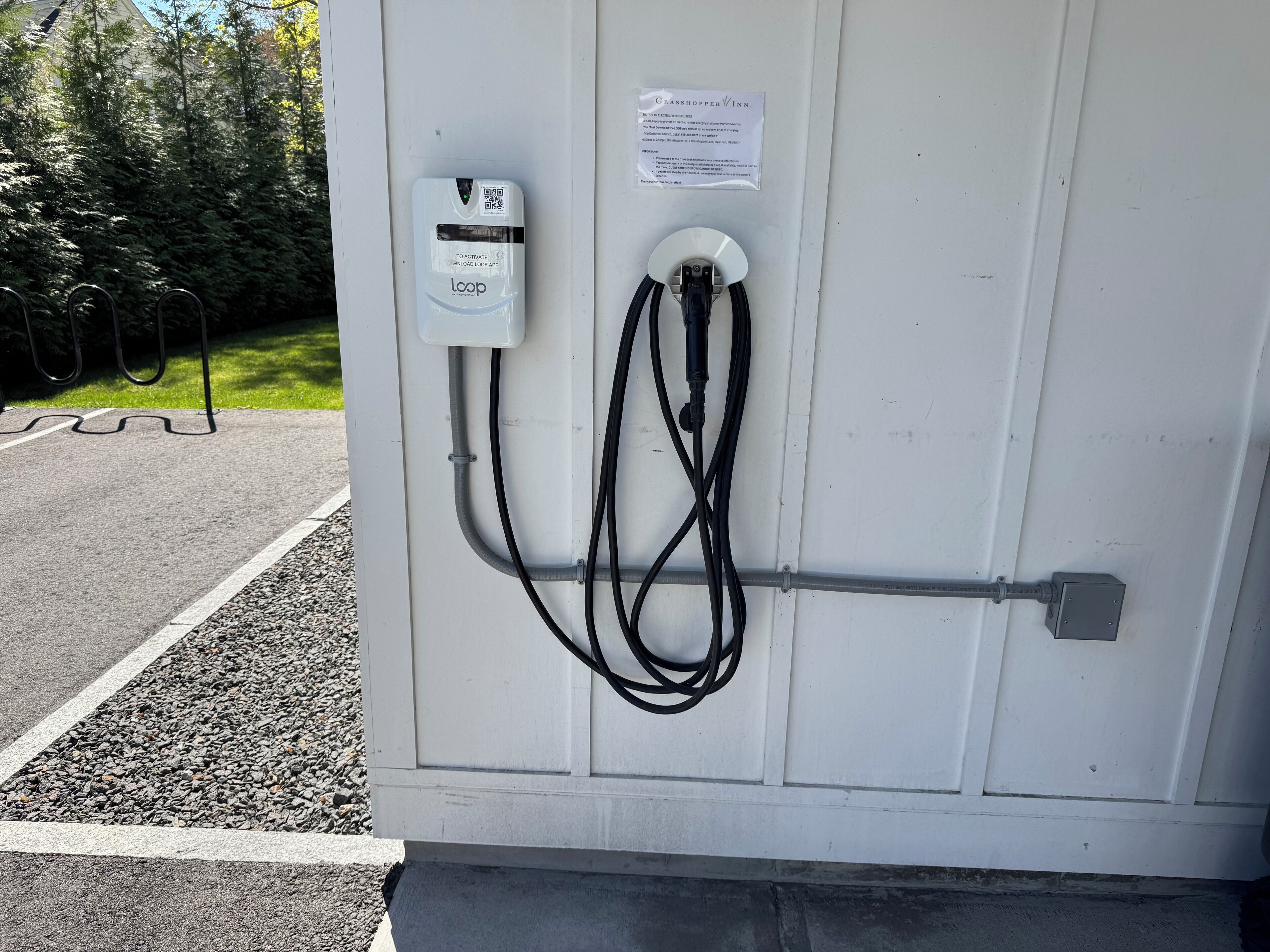 An electric vehicle charging station with a loop cable connected to a white box labeled "LOOP" and a QR code.