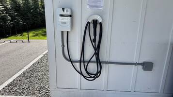 An electric vehicle charging station with a loop cable connected to a white box labeled "LOOP" and a QR code.