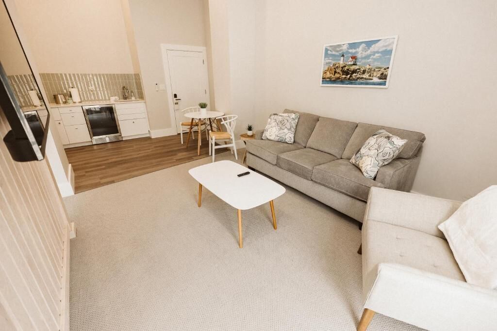A compact living space with a kitchenette, a sofa, a coffee table, and a dining area.