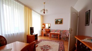 A living room with a sofa, television, and a dining table. - Geovita Dabki (Darlowo)