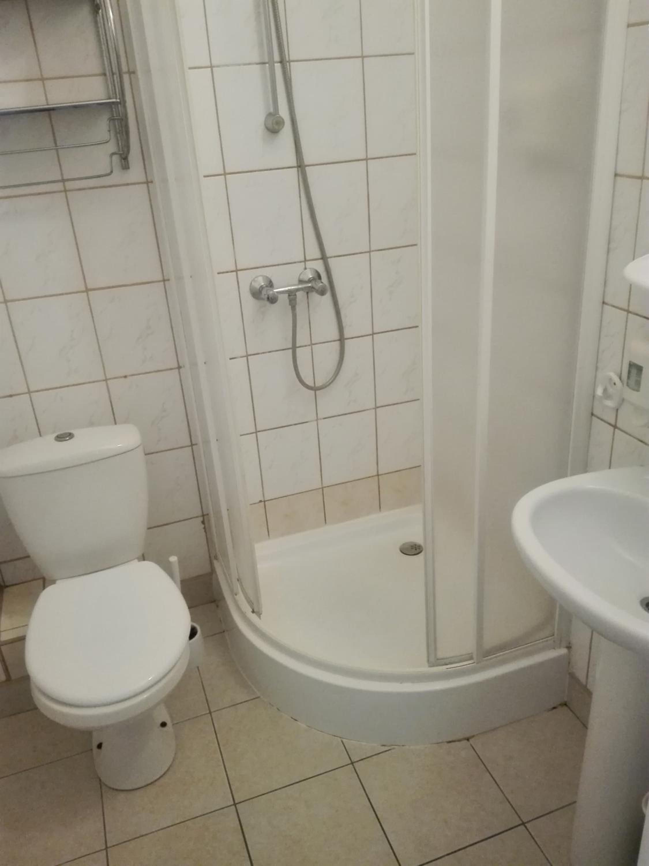 A bathroom with a toilet, a shower enclosure, and a sink.