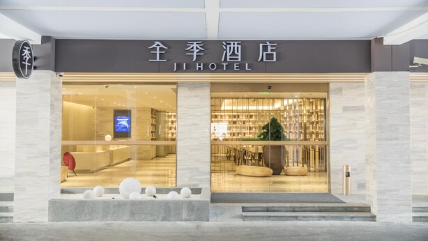 The exterior of Ji Hotel with a modern facade, large glass windows, and a visible reception area. - Ji Hotel Shanghai New Jiangwan City Yingao Road (Shanghai)