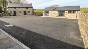 A stone building with a gravel driveway and a stone wall. - The Byre (Bridgend)