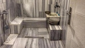 A modern bathroom with a marble floor, a freestanding bathtub, and a shower area. - oldmile palace hotel (Istanbul)