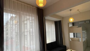A hotel room with a bed, a small table, a chair, and a mirror. - oldmile palace hotel (Istanbul)