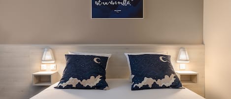 Un dormitorio con cama, dos lámparas de noche y una cita en la pared.