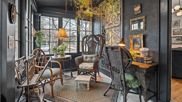 A cozy room with wicker furniture, a patterned rug, and decorative wall art. - La Bella Rosa, Queen Street is your backyard! (Niagara-on-the-Lake)