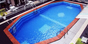 A rectangular swimming pool with a red border and metal railings. - De Castle Luxury Home (Uyo)