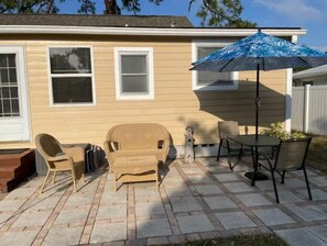 Relax on the patio with wicker furniture and a shaded table.