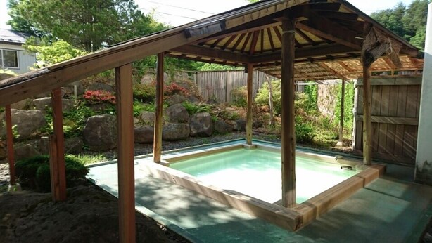 A wooden deck with a pool, surrounded by rocks and plants. - Nakanosawa Onsen Ryokan Shirokiya (Inawashiro)