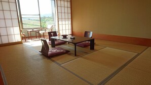 A tatami mat room with a low table and chairs, a view of the outdoors, and a sliding door. - Nakanosawa Onsen Ryokan Shirokiya (Inawashiro)