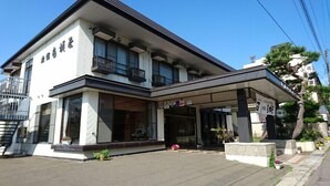 A two-story building with a covered entrance and a signboard. - Nakanosawa Onsen Ryokan Shirokiya (Inawashiro)