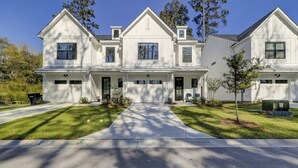 A two-story white house with a front porch, a garage, and a driveway.