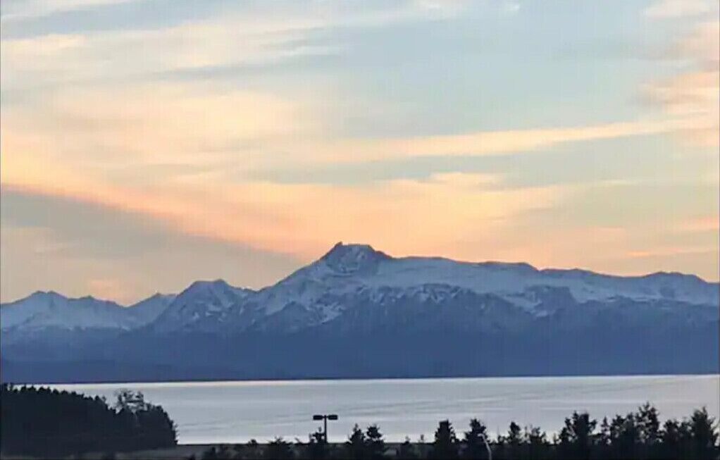 Ein Gebirge mit einem See im Vordergrund.