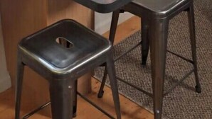 Un espacio para el desayuno con una mesa, dos taburetes y una pequeña barra.