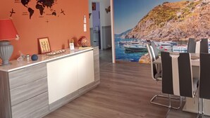 Una cocina moderna con un mapa mundial en la pared, un área de comedor con un mural costero y una araña.