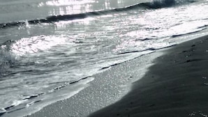 Una playa con olas y un cielo nublado.